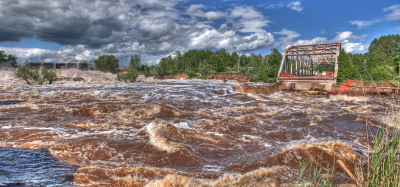 Flood waters washing out road and bridge in District 1