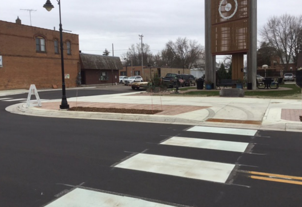 An intersection along Hwy 24 after construction, showing curb extensions, new sidewalk and decorative pavers, and improved crosswalks