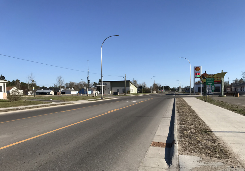 Highway 371 after construction, showing a new sidewalk, lane adjustment, and shared-use path.