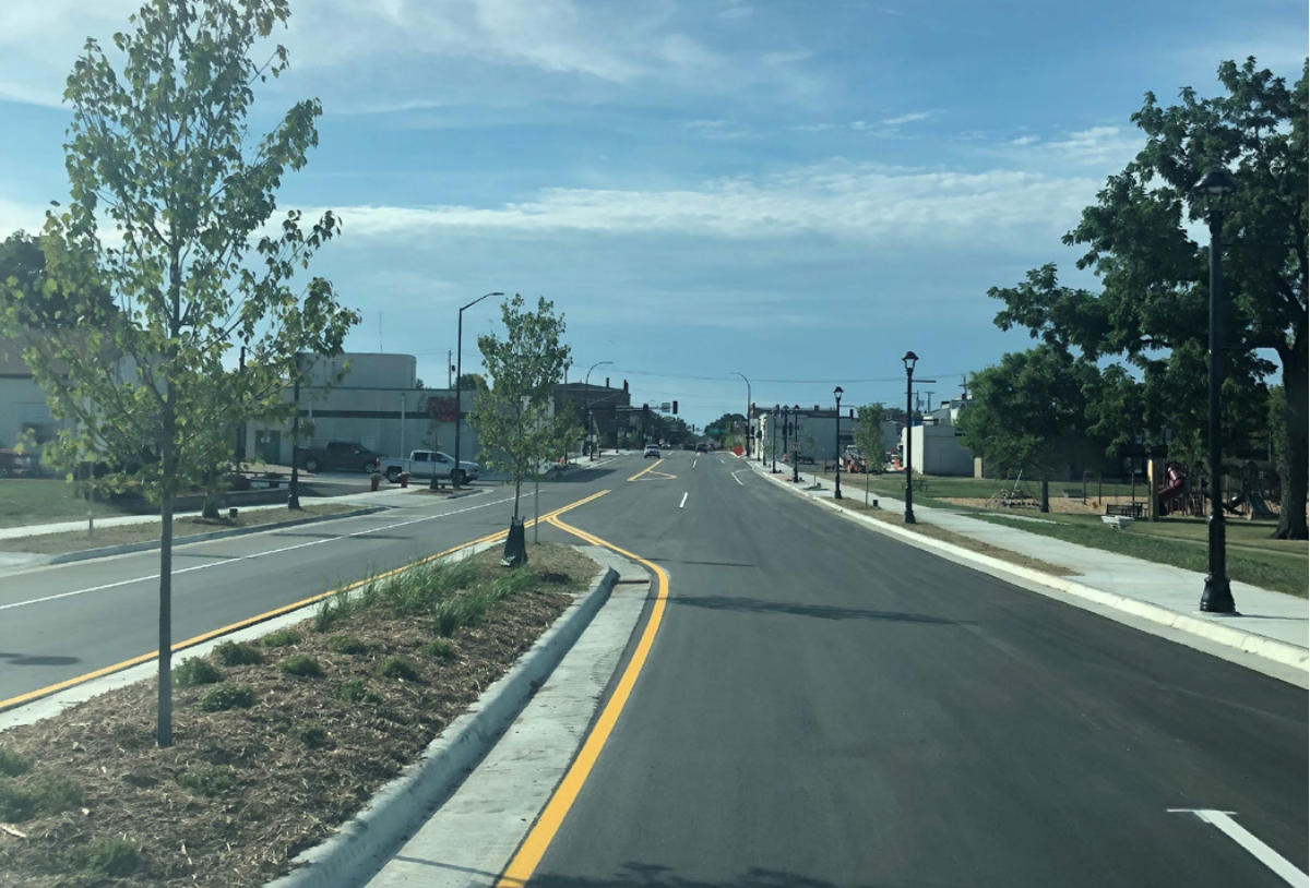 Highway 61 in Lake City, MN after construction, showing planted median, lane adjustment, sidewalks, and shared-use path