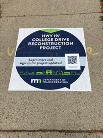 A sidewalk decal with a QR code helps residents track project progress