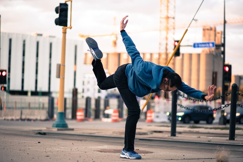 A man dancing in an urban space.
