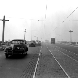 Looking west at traffic on the Third Avenue Bridge. Note streetcar tracks and overhead wires attached to the light posts powering the streetcar