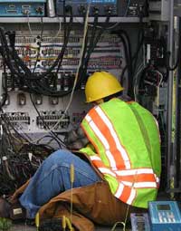 Electrician installing cables in the traffic signal cabinet
