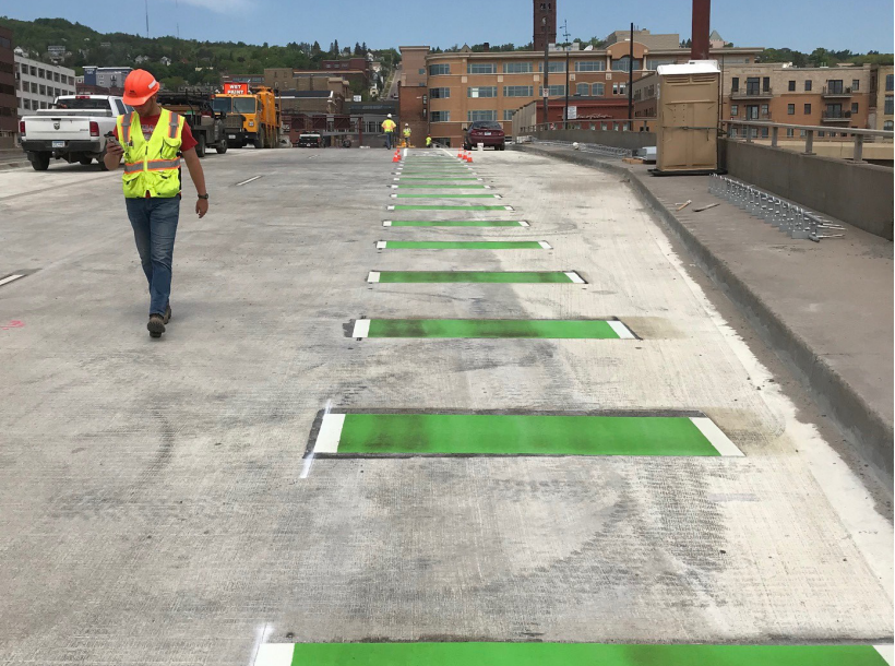 Lake Ave. bridge over Hwy 35 during construction, showing green striped bike lane and new sidewalk