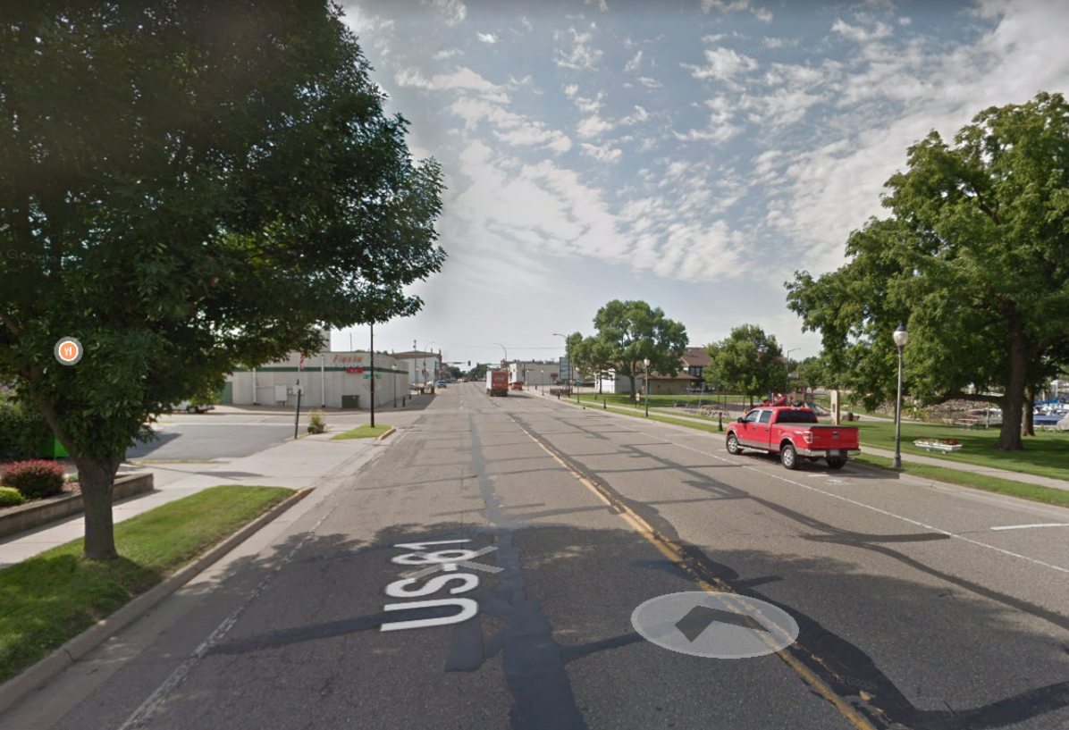 Highway 61 in Lake City, MN before construction, showing three traffic lanes and a narrow sidewalk