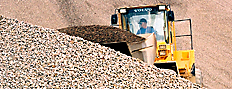 Pay loader scooping from an aggregate pile