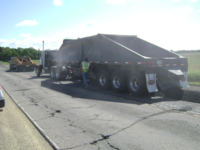 Belly dump truck putting down asphalt