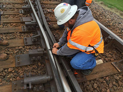 Employee inspecting railroad tracks