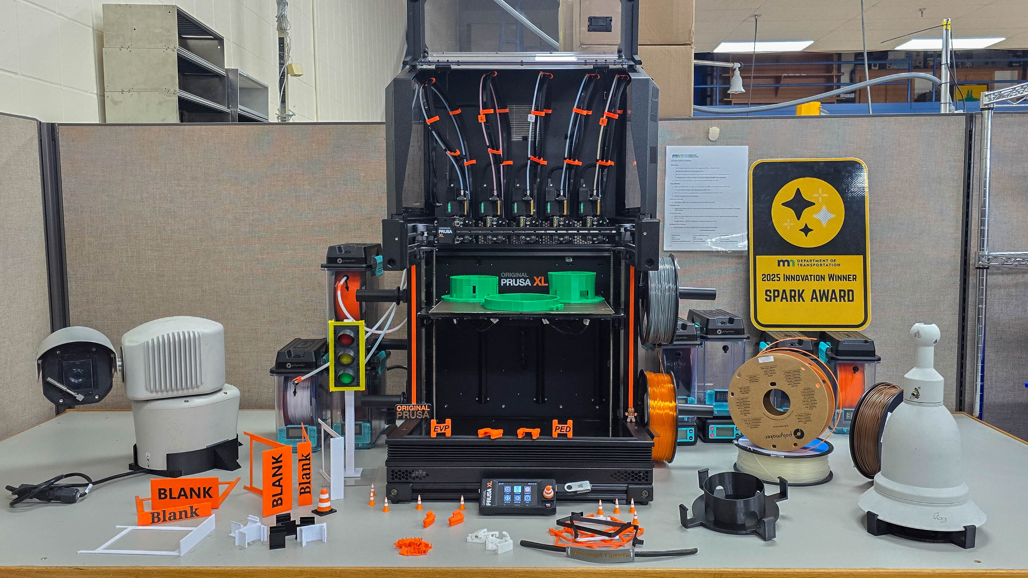 photo of 3D printer with display of parts created for the traffic signal cabinets