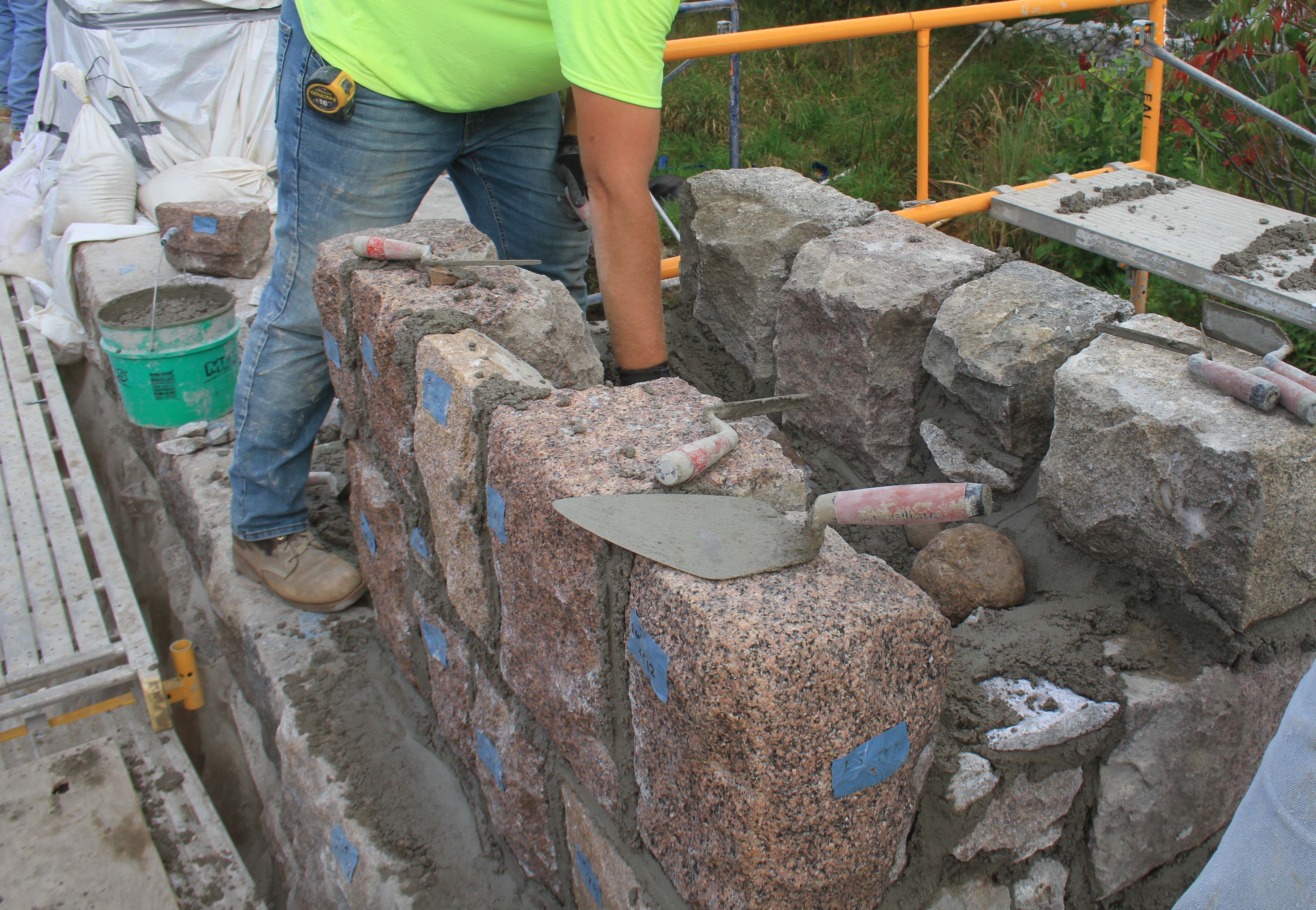 Work underway removing labelled stones and removing old mortar. Stones will be stored on pallets until they are ready for reinstallation. July 2018.