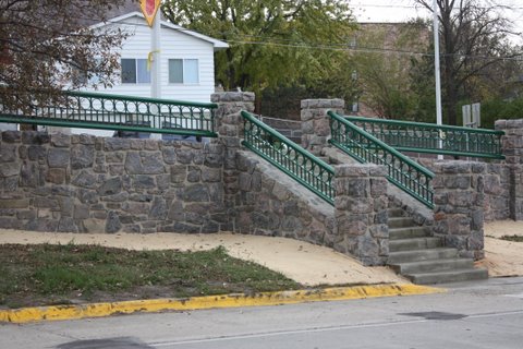 The same wall after restoration in 2011, featuring restored stone masonry and its steel rail back to the original color.