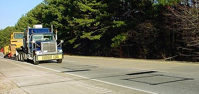 A truck with an "Oversize Load" sign approaches a weigh-in-motion site